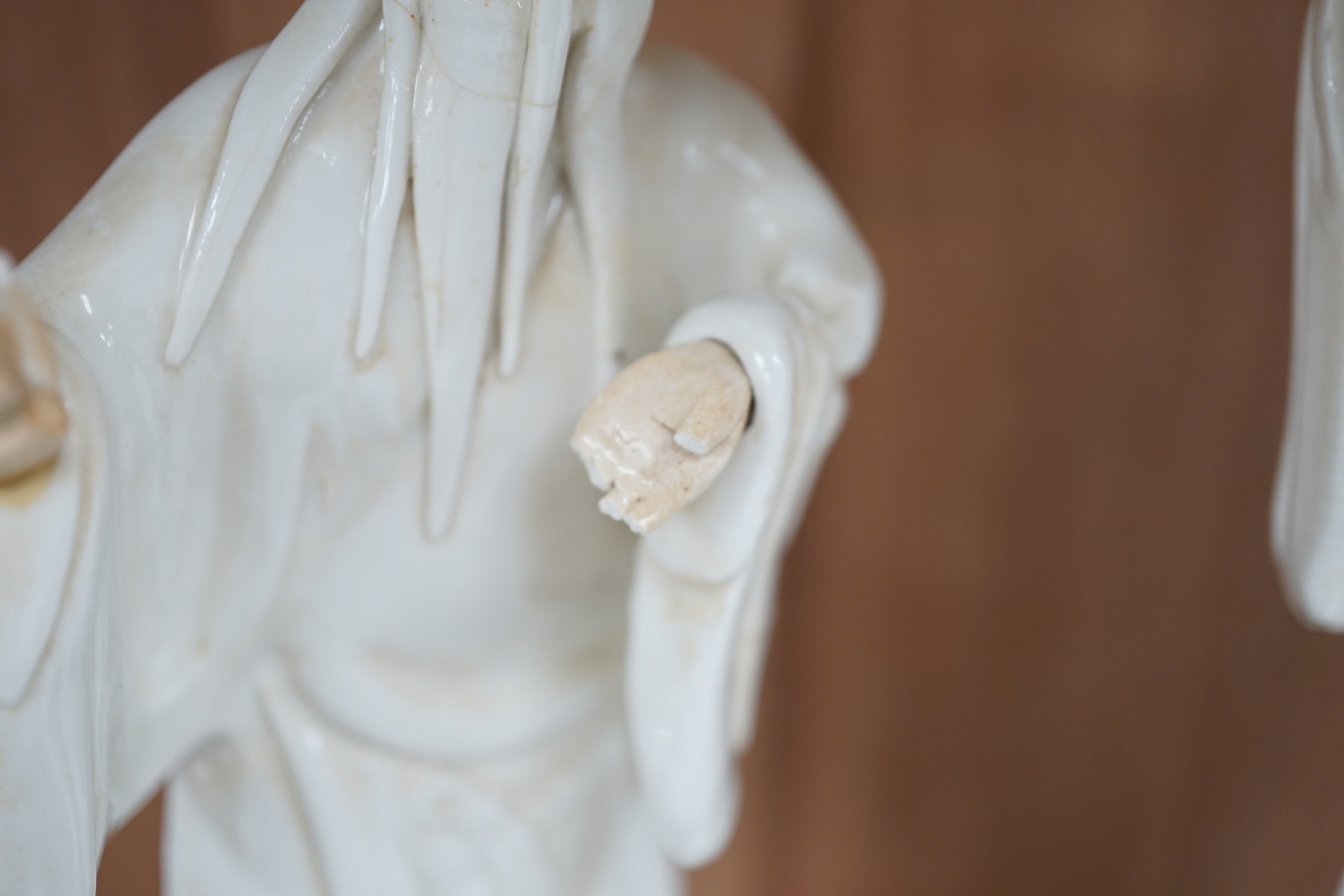Seven Chinese blanc de Chine figures of immortals, each raised on carved hardwood bases, the largest 24cm high
